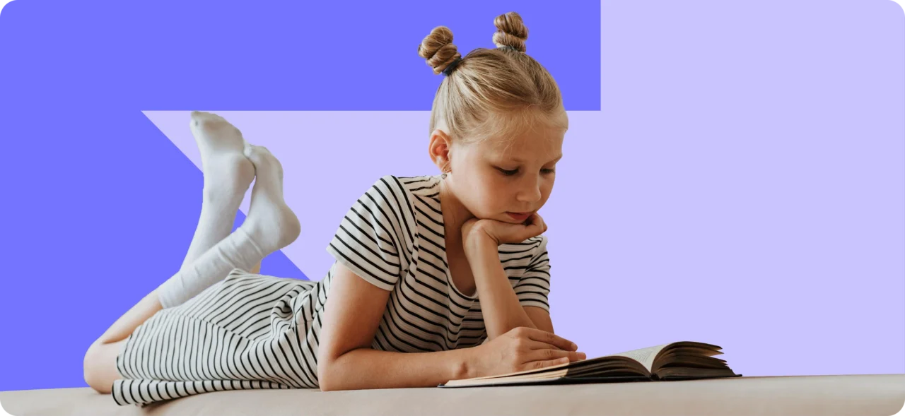 Child lying on a sofa and reading a book