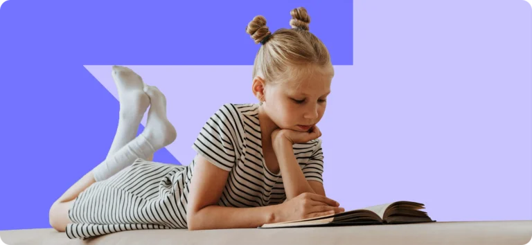 Child lying on a sofa and reading a book
