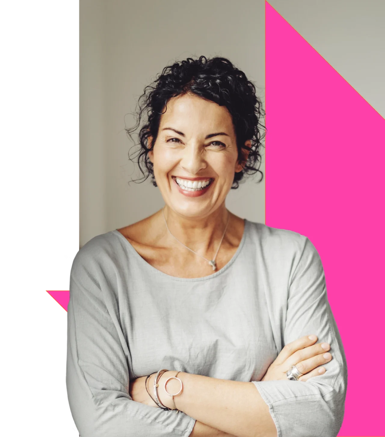 Smiling adult standing against a pink background