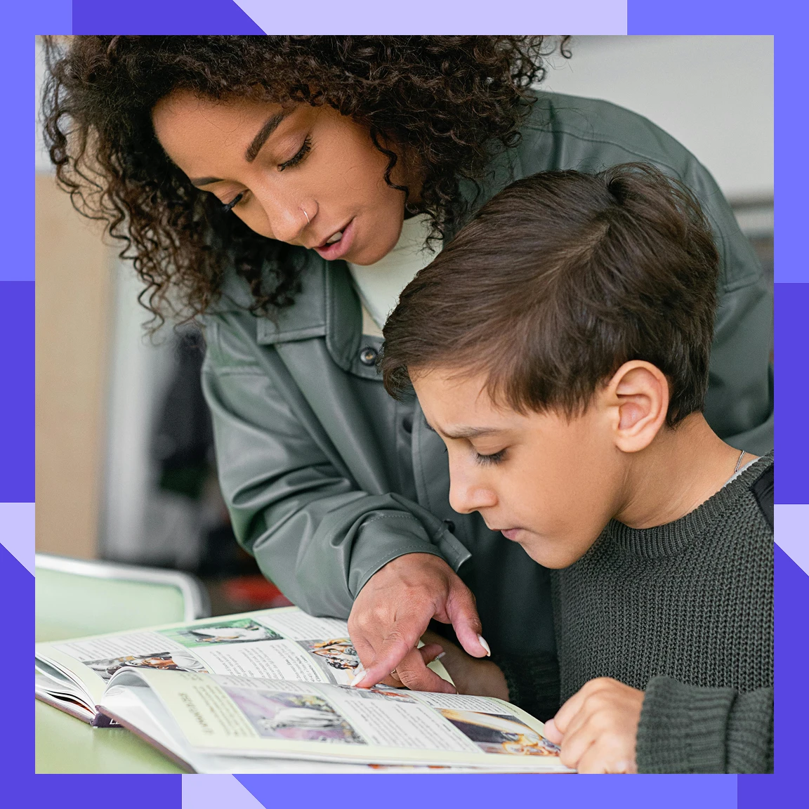 Adult supporting a child while reading a book together