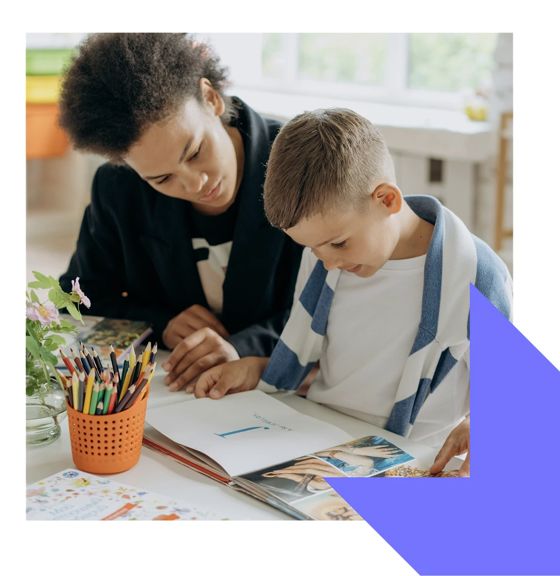 Adult helping a child with reading or writing at a table