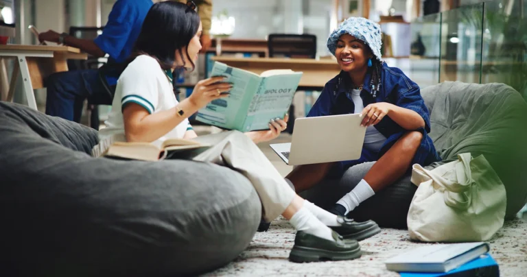 Two young people sitting on beanbags and reading together