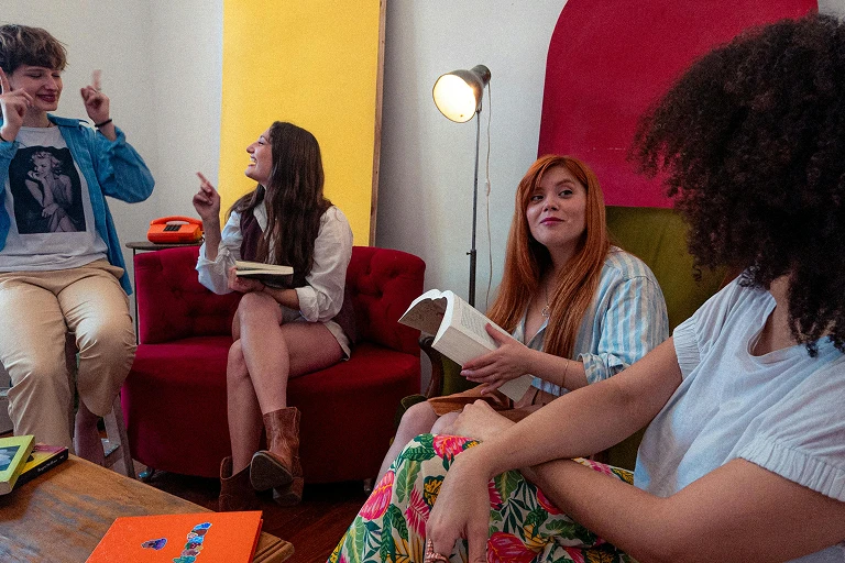 Two adults sitting on a sofa and reading books together