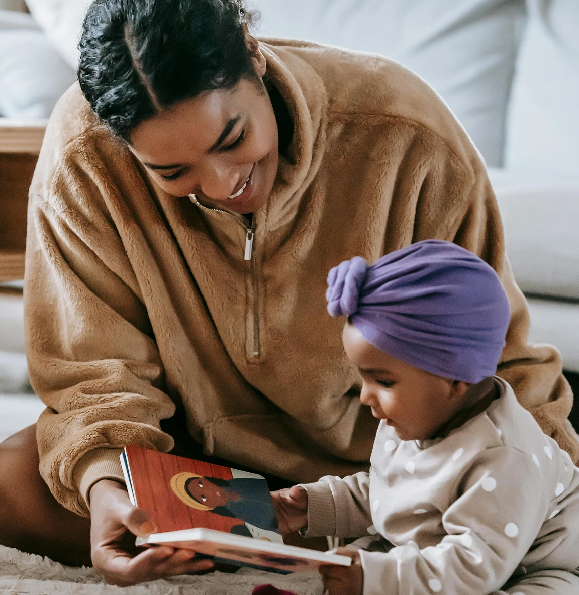 Adult and baby sitting together and looking at a book