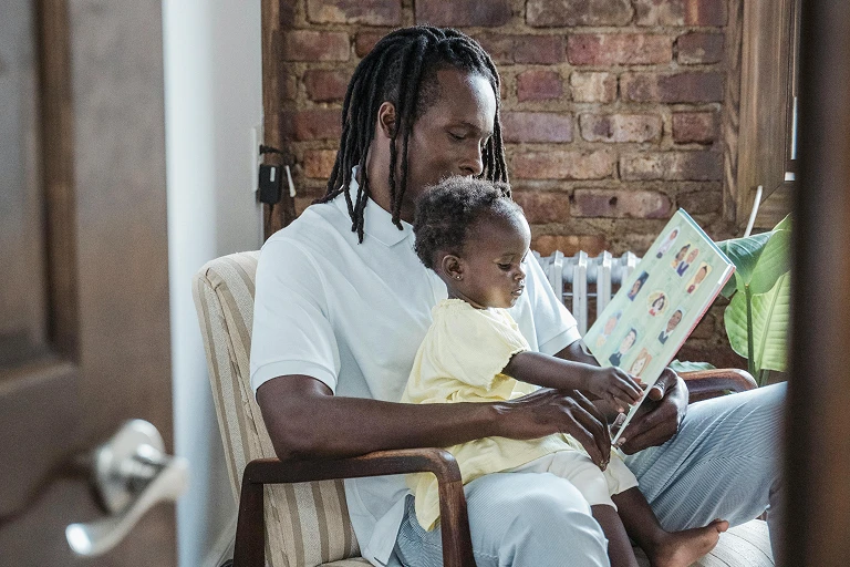 Adult reading a picture book aloud to a young child at home