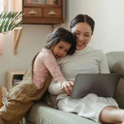 Parent and young child reading together at home on a sofa