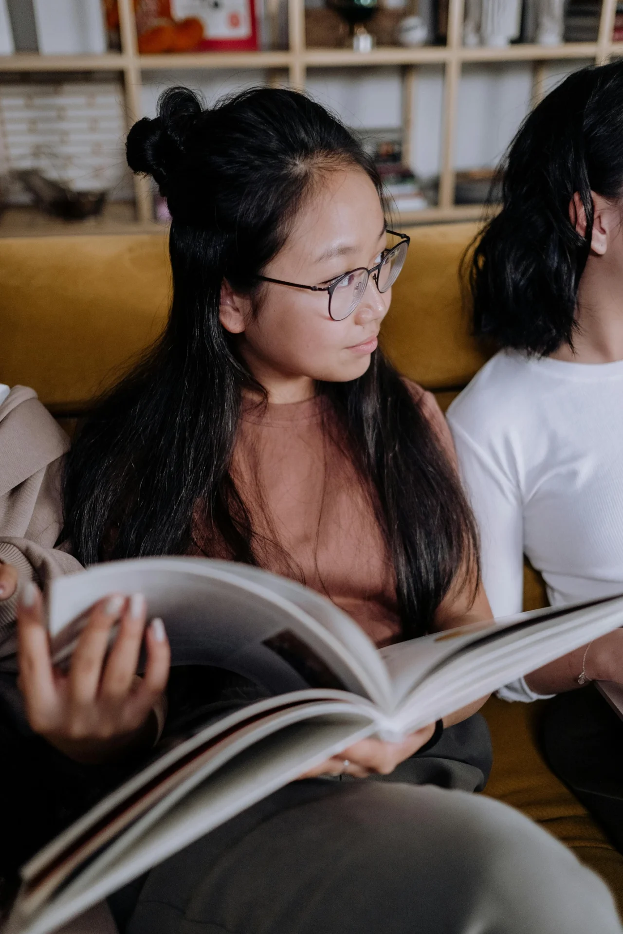 Young adults sitting together and reading a book
