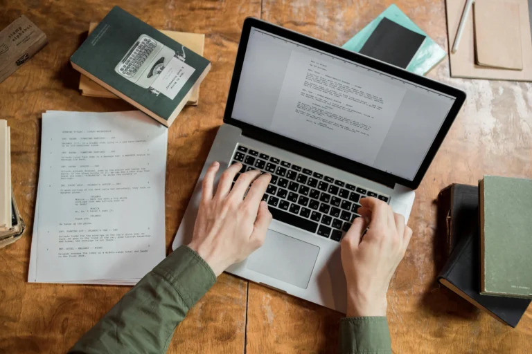 A top down view of a desk with someone working on their laptop
