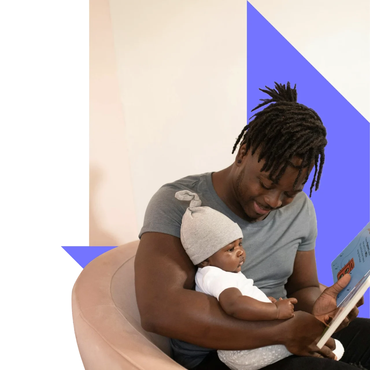 Young father reading a picture book whilst cradling his newborn child