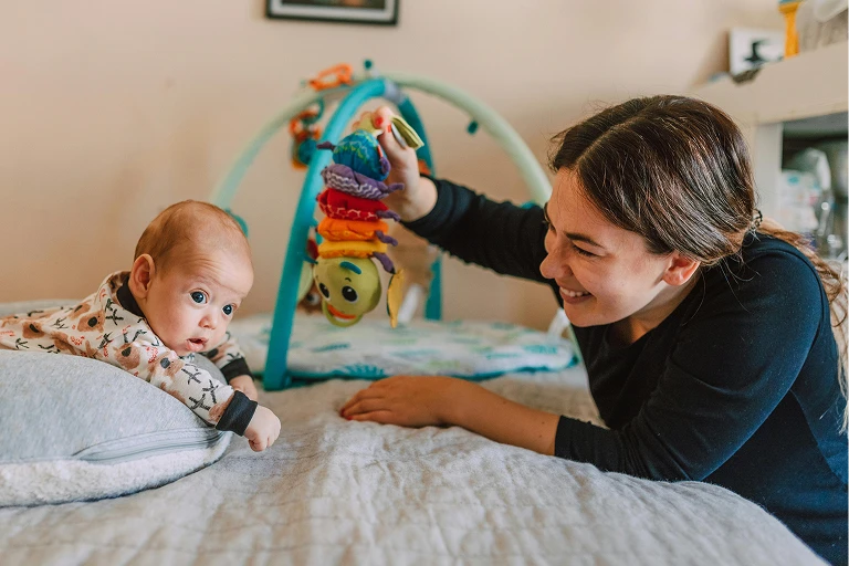 Mum playing with a mobile in front of her newborn baby