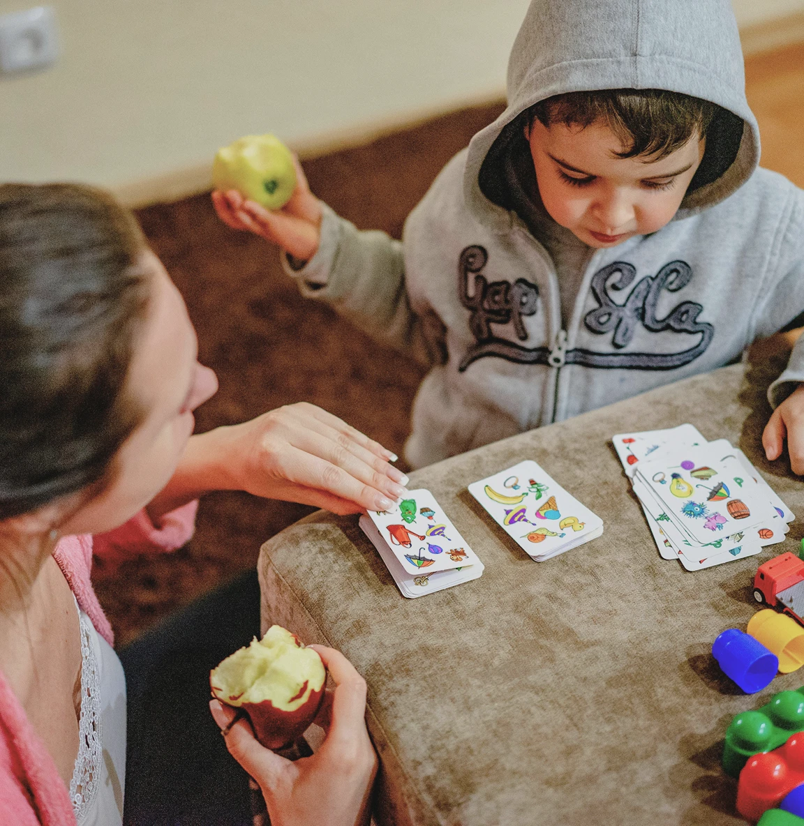 Caregiver and young boy playing with picture cards