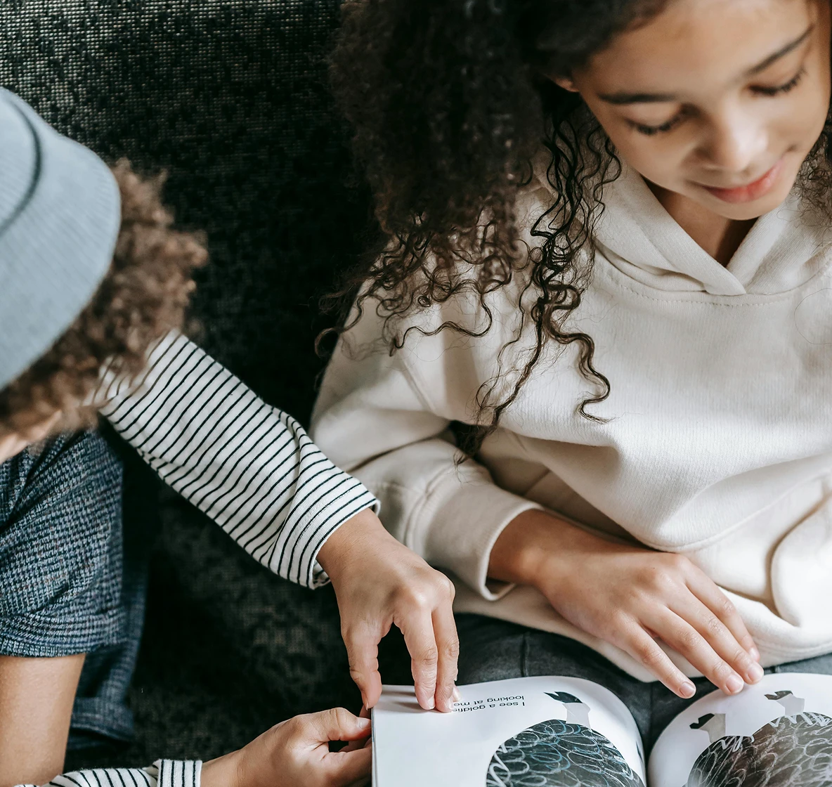Two young children reading a picture book together
