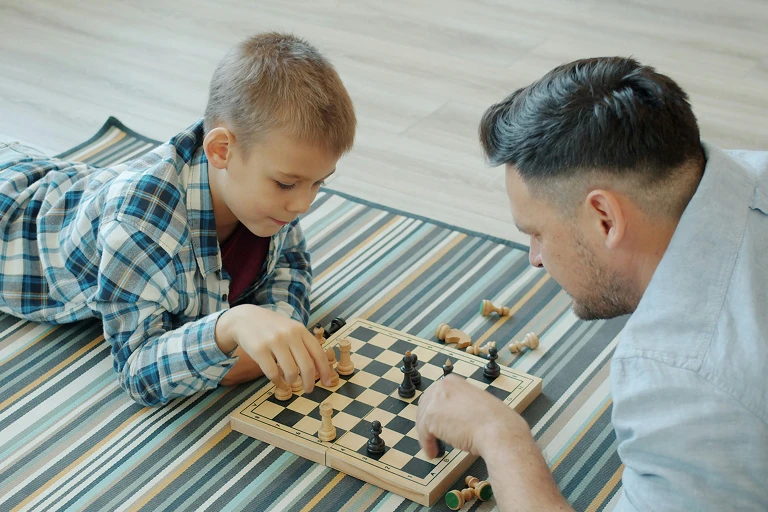 Boy and Dad playing chess together