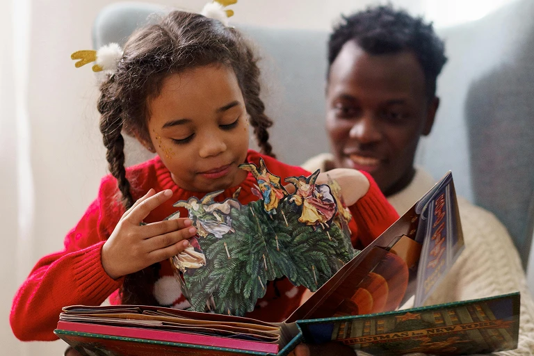 Father and daughter reading a picture book together