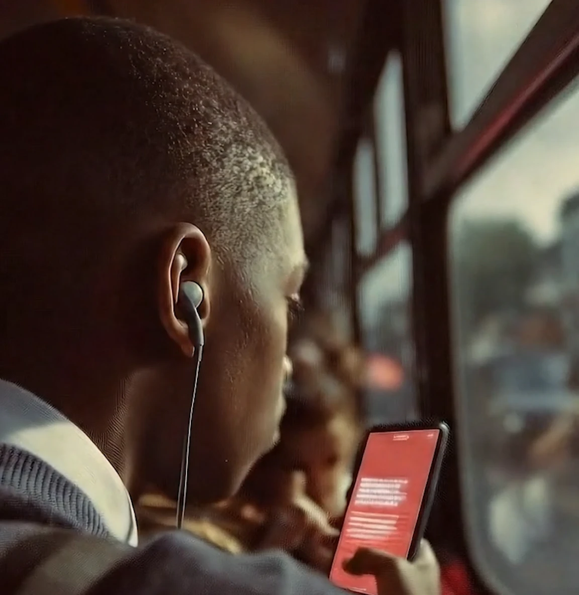 Teen boy riding the bus and reading his phone
