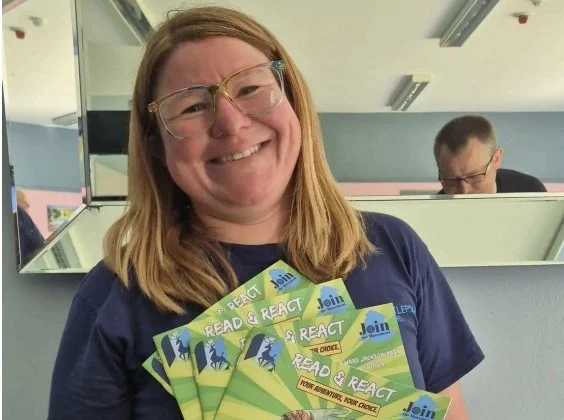 Image showing a lady smiling and holding up several booklets